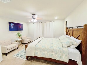 A bedroom with a bed, a chair, a TV, and a ceiling fan. - Newly Built 3-bedroom modern house with parking in vibrant Downtown San Antonio (San Antonio)