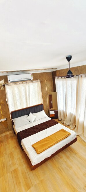 A single bed with a headboard, a bedside table, a mirror, and a ceiling fan. - Cozy Homestay Steps Away from Alappuzha Beach (Alappuzha)