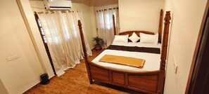 A bedroom with a wooden bed, white curtains, a potted plant, and a white wall. - Cozy Homestay Steps Away from Alappuzha Beach (Alappuzha)