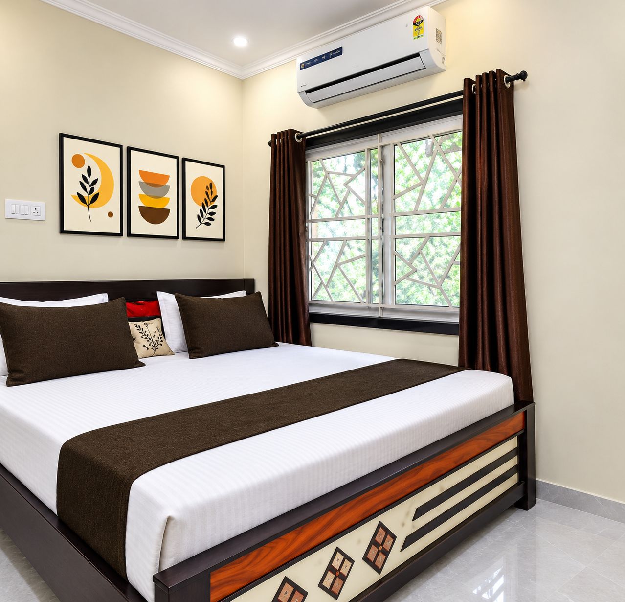 Habitación de hotel con cama, unidad de aire acondicionado, ventana con cortinas y decoración en la pared.