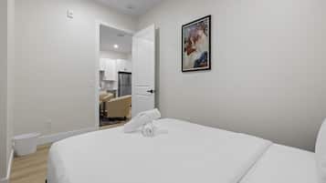 Een hotelkamer met een bed, een schilderij en uitzicht op de keuken.