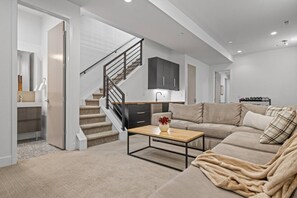 Lower-level family room with sectional seating, smart TV, wet bar, weights, and foosball table - Denver Designer Retreat | Hot Tub | Rooftop Decks (Denver)