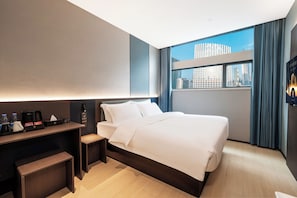 A modern hotel room with a bed, bedside table, and a view of the cityscape. - Caelum Gaudia Hotel (Guangzhou)