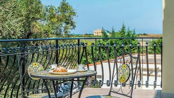 Un balcone con un tavolo apparecchiato per due, con un piatto di cibo e una tazza.