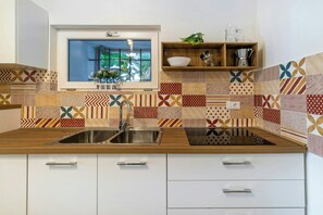 A kitchen with a wooden countertop, a stainless steel sink, and patterned backsplash tiles. - Villa with pool, hot tub and annexe in Bisceglie (Bisceglie)