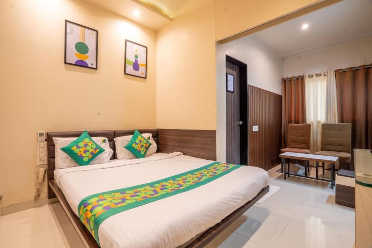 Une chambre d’hôtel avec un lit, un bureau, une chaise et une porte.
