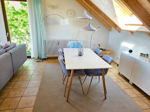 Ein modernes Interieur mit Esstisch, Stühlen, einer Couch und einer Heizung.