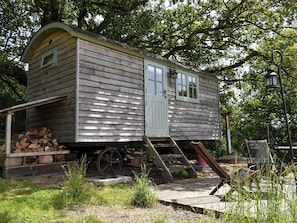 A wooden cabin with a front door, windows, and a small porch area. - Romney Hut - UKC4067 (West Bagborough, near Taunton)