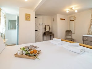 A hotel room with a bed, a bedside table with a tray of breakfast items, a mirror, and a chair. - 1 bedroom accommodation in Knodishall, near Aldeburgh (Knodishall, near Aldeburgh)