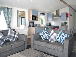 A compact living space with a kitchenette, a sofa set, and a dining area. - 3 bedroom accommodation in Budleigh Salterton (Budleigh Salterton)