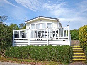 A mobile home with a white exterior, a balcony with a railing, and a number '22' sign. - 3 bedroom accommodation in Budleigh Salterton (Budleigh Salterton)