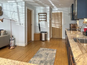 A modern kitchen with a granite countertop, wooden cabinets, and a built-in oven. - Springwood Cottage - UKC9437 (Holmesfield)