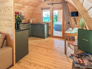 A cozy wooden cabin interior with a kitchen, dining area, and a small seating space. - Laurel Lodge - UKC9519 (Gillingham, near Beccles)