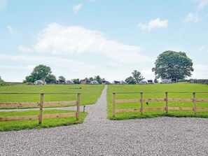 A gravel path leading to a wooden fence with a view of a green field and trees in the distance. - Ingleborough Dome - UKC9594 (Clitheroe and the Ribble Valley)