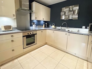 A kitchen with a built-in oven, a sink, and cabinets. - 2 bedroom accommodation in Whitby (Whitby)