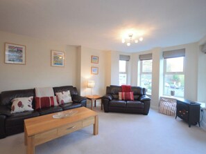 A living room with two sofas, a coffee table, and a fireplace. - 2 bedroom accommodation in Whitby (Whitby)