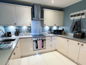 A modern kitchen with a built-in oven, a microwave, and a toaster. - 2 bedroom accommodation in Whitby (Whitby)