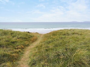 A coastal path leading to the sea with grassy banks and a clear sky. - 2 bedroom accommodation in Llanengan (Llanengan)