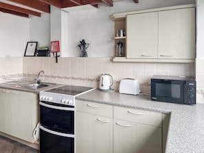 A kitchen with a stove, toaster, microwave, and cabinets. - 2 bedroom accommodation in Llanengan (Llanengan)