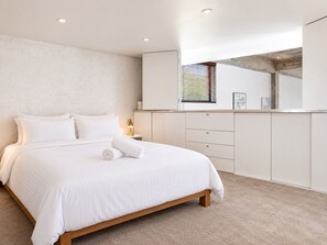 Ein Schlafzimmer mit einem Bett, einem Nachttisch, einer Lampe, einem Kleiderschrank und einem Fenster mit Jalousien.