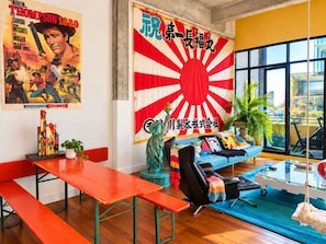 A modern living room with a large window, a sofa, a statue, and a poster on the wall. - Balcony 1-Bed Apartment Near Sydney Road (Brunswick)