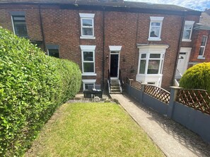 A residential building with a brick facade, multiple windows, and a well-maintained lawn. - 4 bedroom accommodation in Whitby (Whitby)