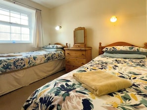 A bedroom with two single beds, a dresser, a mirror, and a window. - 2 bedroom accommodation in Whitby (Whitby)