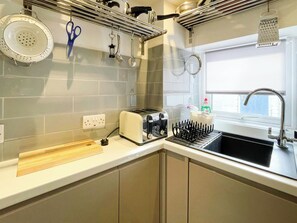 A kitchen with a toaster, a sink, and a window. - 2 bedroom accommodation in Whitby (Whitby)