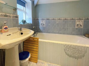 Ein Badezimmer mit Waschbecken, Badewanne und Fenster.