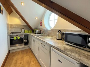 A kitchen with a gas stove, oven, microwave, and a sink. - 2 bedroom accommodation in Whitby (Whitby)