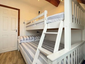 A bunk bed with a ladder, a door, and a wooden floor. - 2 bedroom accommodation in Whitby (Whitby)