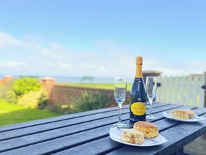A picnic table with a bottle of Prosecco, two glasses, and biscuits. - 1 bedroom accommodation in Whitby (Whitby)