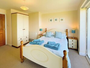 A bedroom with a bed, bedside tables, a wardrobe, and a radiator. - 1 bedroom accommodation in Whitby (Whitby)