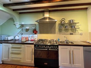 A kitchen with a gas stove, oven, and a sink. There are cabinets, a toaster, and a kettle on the counter. - 3 bedroom accommodation in Whitby (Whitby)