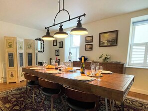 A dining area with a wooden table set for four, equipped with wine glasses and a bottle. - 3 bedroom accommodation in Whitby (Whitby)