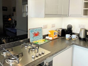 A kitchen with a gas stove, a coffee maker, a toaster, and a sign indicating a seafood market. - 1 bedroom accommodation in Whitby (Whitby)