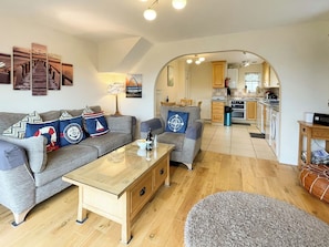 A living room with a sofa, coffee table, and artwork on the wall. - 2 bedroom accommodation in Whitby (Whitby)