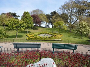 A park with a central circular flower bed, benches, and a variety of trees. - 2 bedroom accommodation in Whitby (Whitby)
