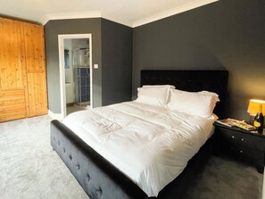A bedroom with a large bed, a wooden wardrobe, and a walk-in closet. - 5 bedroom accommodation in Whitby (Whitby)
