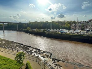 A river with boats docked on the right, a bridge in the background, and a grassy area on the left. - 2 bedroom accommodation in Whitby (Whitby)