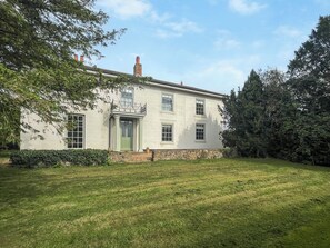 A two-story building with a green door and a balcony. - 5 bedroom accommodation in Walesby (Walesby)