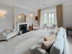 A spacious living room with a fireplace, comfortable seating, and large windows. - 5 bedroom accommodation in Walesby (Walesby)