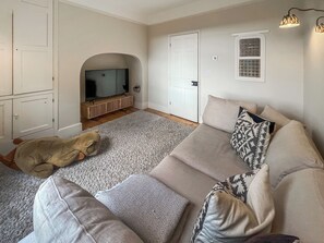 A living room with a sofa, a television, a patterned rug, and a teddy bear. - 5 bedroom accommodation in Walesby (Walesby)