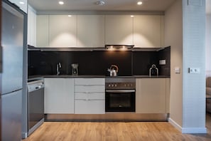 A modern kitchen with stainless steel appliances, a built-in oven, and a kettle on the countertop. - MH Apartments Plaza Europa (L'Hospitalet de Llobregat)