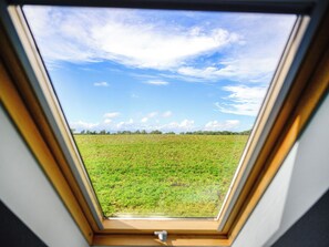 A skylight with a view of a green field and a clear blue sky. - The Carriage House - UKC6967 (Carnoustie)