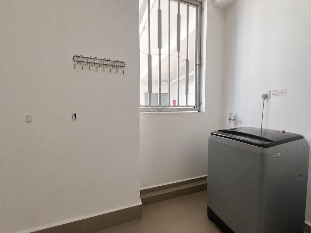 Una habitación con ventana, un radiador y un cubo de basura.