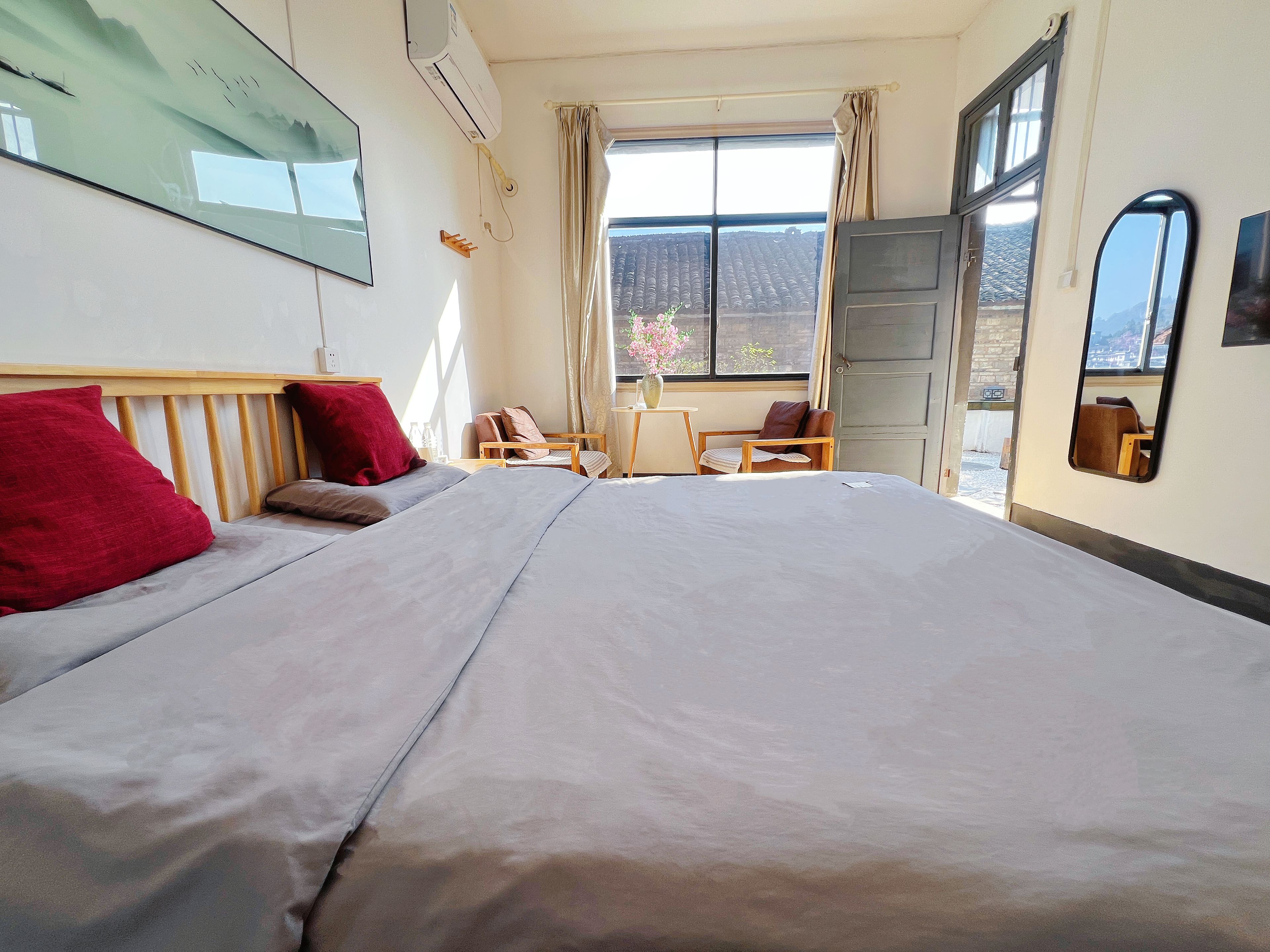 Une chambre d’hôtel avec un lit, un bureau, une chaise et une fenêtre donnant sur un paysage agréable.