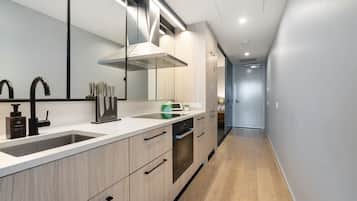 A modern kitchen with a double sink, a range hood, and wooden cabinetry.