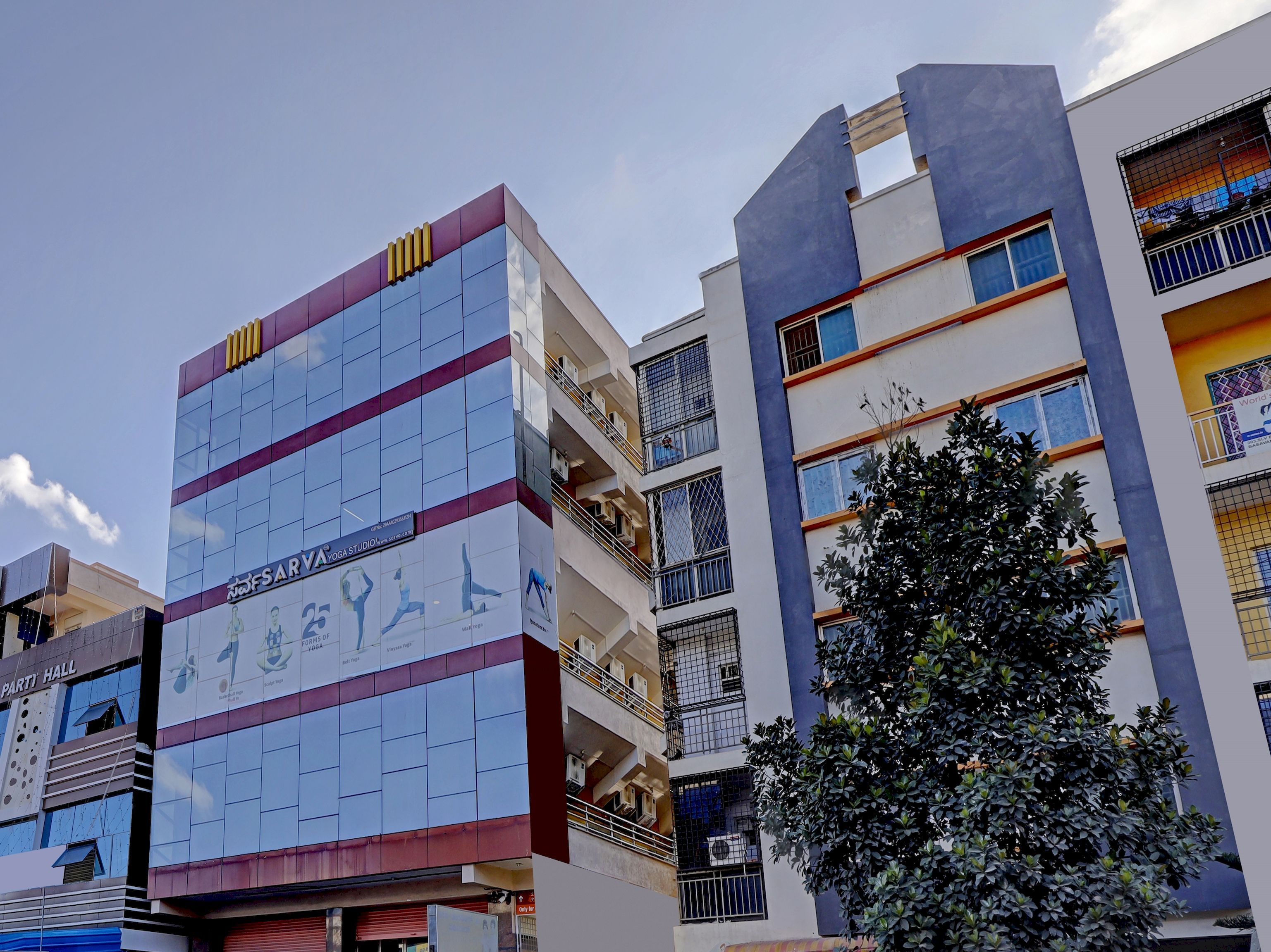 A multi-story building with a prominent sign for a yoga studio on the ground floor.