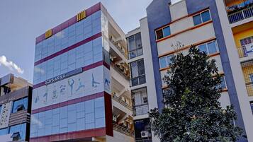 A multi-story building with a prominent sign for a yoga studio on the ground floor.